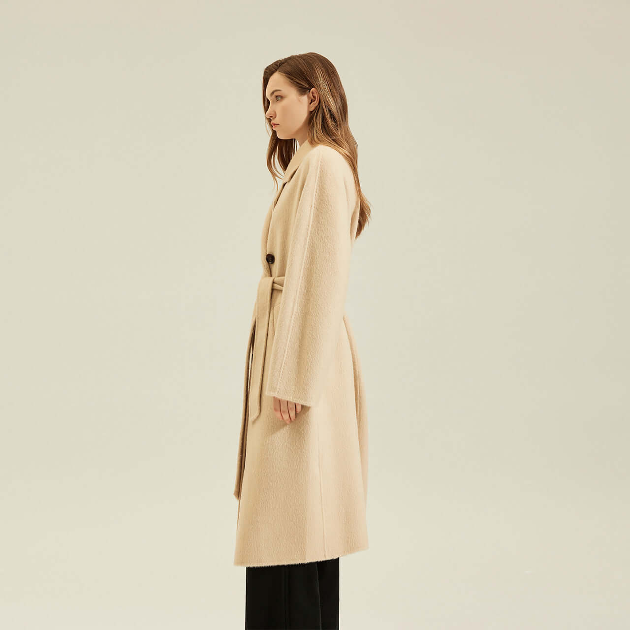 Women's Camel Coat Reversible Woolen Jacket displayed on a model showcasing its elegant side profile and soft beige color.